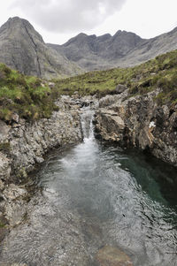 Scenic view of river amidst mountains against sky