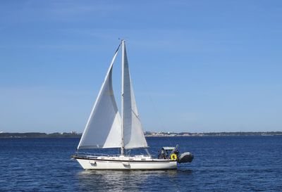 Sailboat sailing on sea against clear sky