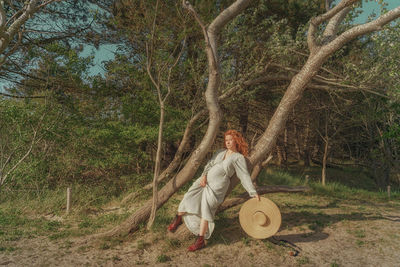 Rear view of woman sitting between trees 