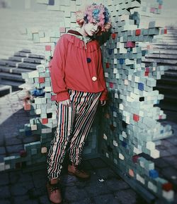 Portrait of young man standing against wall