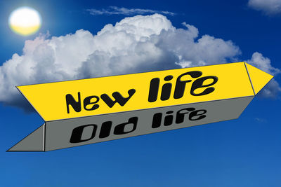 Low angle view of road sign against blue sky