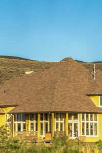 Houses on landscape against clear blue sky