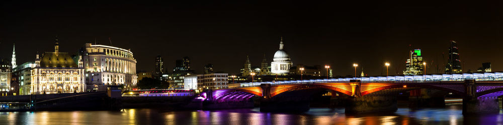 Bridge over river in city at night