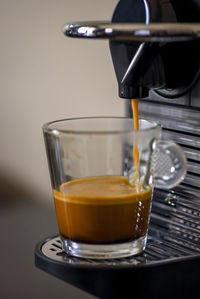 Closeup of cappuccino machine brewing fresh cup of coffee