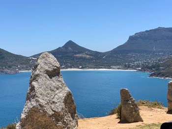 Panoramic view of sea and mountains against clear blue sky