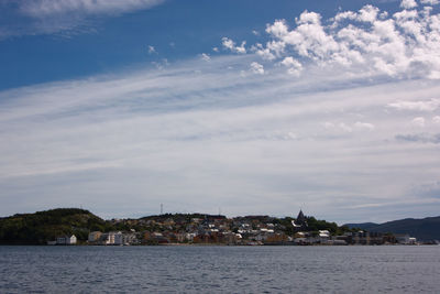 Scenic view of sea by town against sky