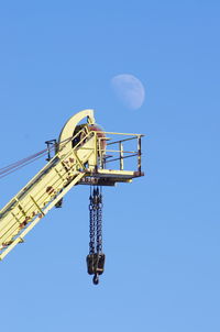 Low angle view of windmill against clear blue sky