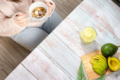 Healthy eat with top view woman eat breakfast with avocado slice and smoothie on wooden board