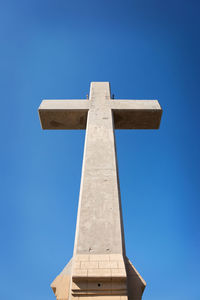 Low angle view of cross against clear blue sky