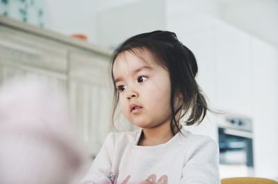 Portrait of cute girl looking away at home