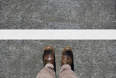 Low section of man standing on road