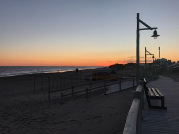 Scenic view of beach against clear sky during sunset