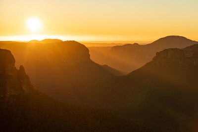 Scenic view of silhouette mountains against sky during sunrise