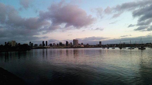 water, waterfront, sky, building exterior, city, architecture, built structure, cloud - sky, sunset, cityscape, river, reflection, cloud, sea, urban skyline, skyscraper, dusk, silhouette, cloudy, skyline