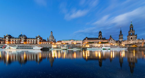 Boats moored on river by dresden frauenkirche at dusk