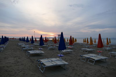 Panoramic view of people at beach during sunset