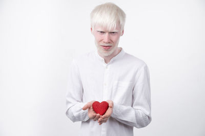 Portrait of smiling man standing against white background