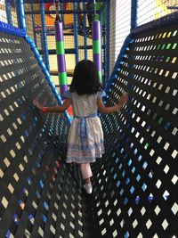 Rear view of girl playing at jungle gym