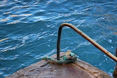 High angle view of rope tied to ocean side