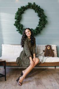 A cute young woman in a joyful mood is ready to celebrate christmas and new year, sitting 