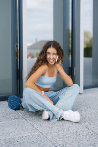 Portrait of young woman sitting on bed at home