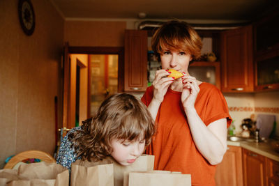 Portrait of boy holding camera at home