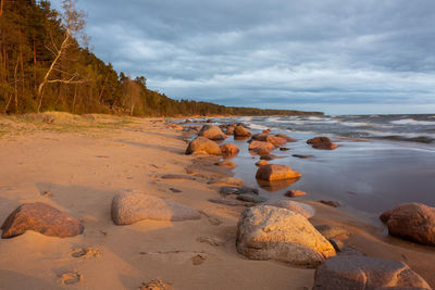 Rocks on beach against sky