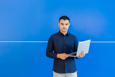 Full length of young man using smart phone