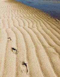 High angle view of footprints on sand at beach