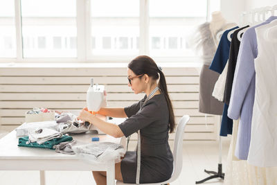 Side view of a woman working on table