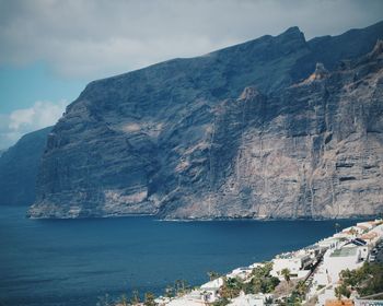 Scenic view of sea and mountains against sky