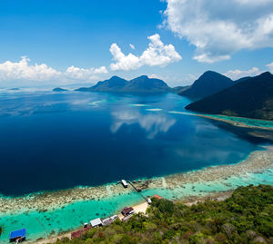 Panoramic view of sea and mountains against blue sky