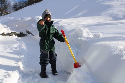 Low section of boy skiing on snow covered field