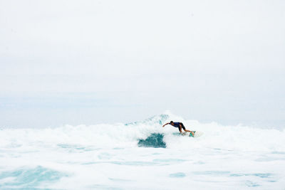 Man surfing in sea against sky