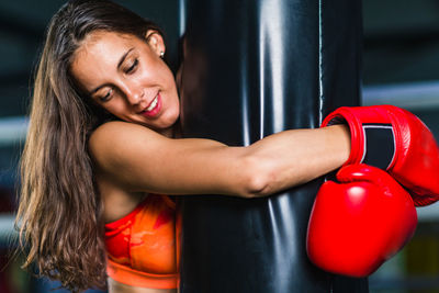 Female boxer holding punching bag in gym