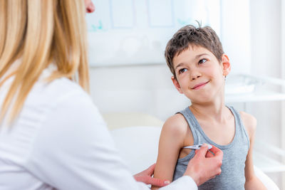 Female doctor examining boy at clinic