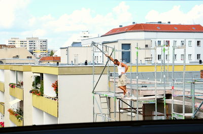 Man standing on scaffolding by building seen through window