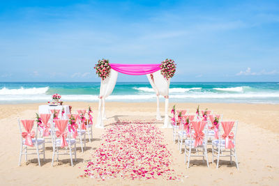 Wedding arrangement at beach against sky