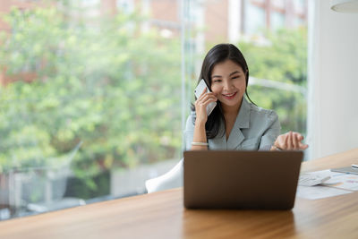 Young woman using laptop at table