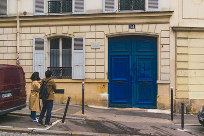 Rear view of people on street against building