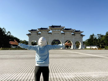 Rear view of woman standing against clear sky