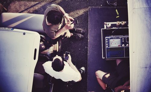 Directly above view of people standing by golf cart with sound recording equipment