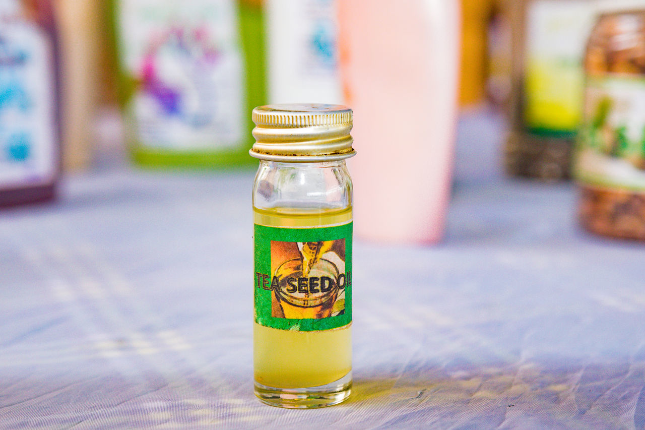 container, yellow, food and drink, jar, focus on foreground, bottle, food, no people, table, indoors, glass, drink, mason jar, wood, close-up