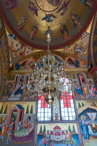 Low angle view of chandelier hanging on ceiling of building