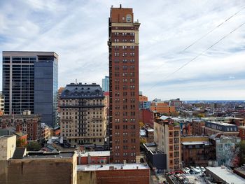 Buildings in city against cloudy sky