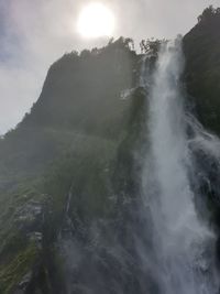 Low angle view of waterfall against sky