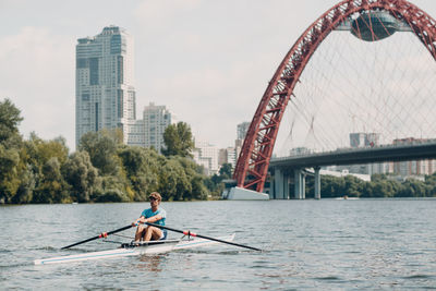 Man on bridge over river in city