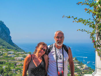 Portrait of smiling friends at sea against sky