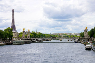 Seine river with pont alexandre iii bridge and eiffel tower in paris, france