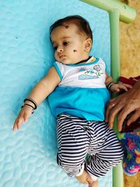 Cute baby girl lying on seat in park